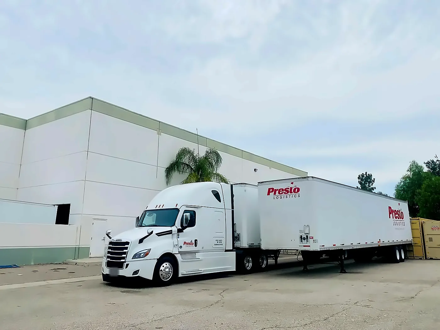 Presto truck and two moving trailers backed up to the warehouse loading docks